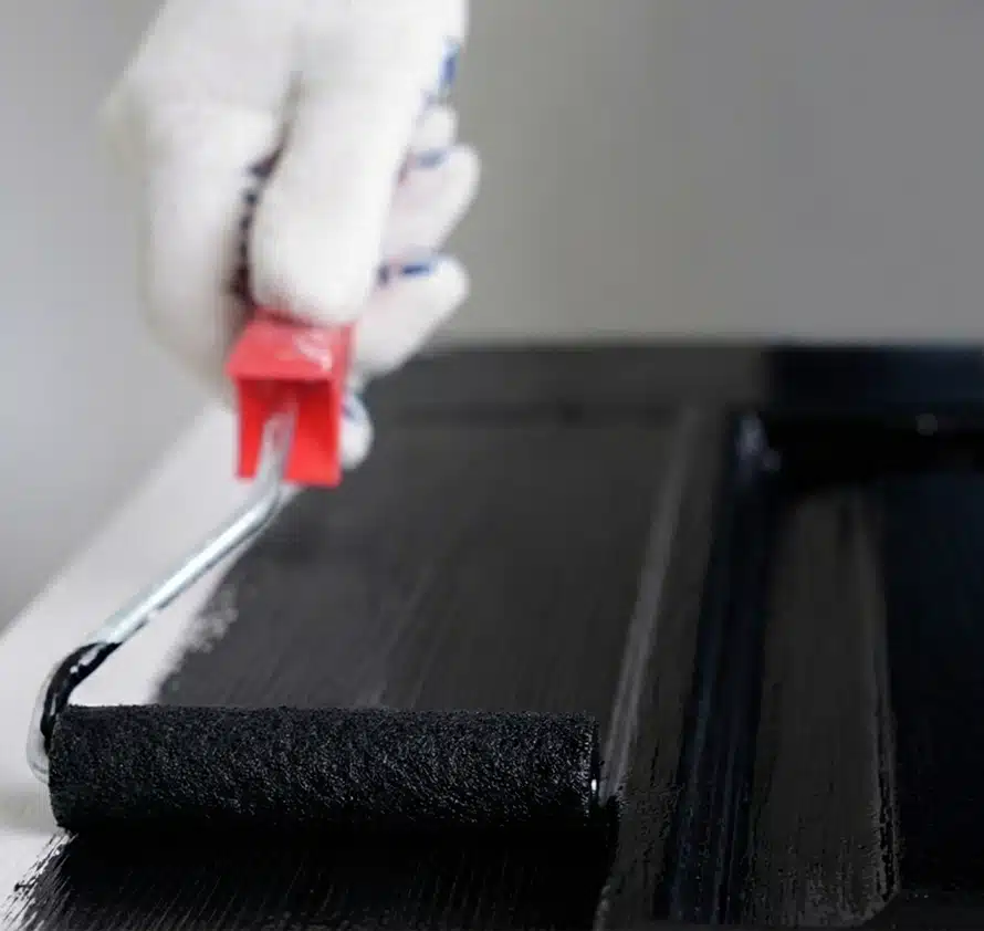 Lakroller waarmee zwarte verf wordt aangebracht